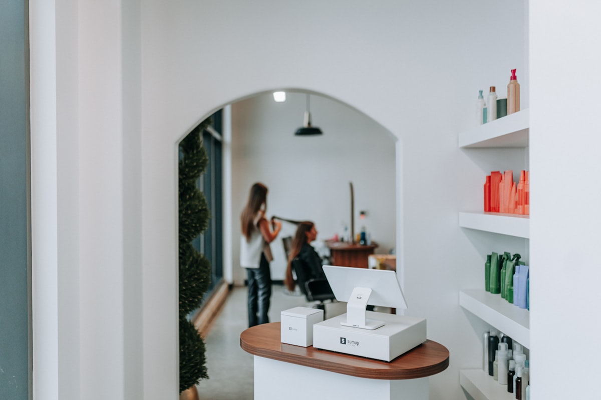 Stylistin frisiert eine Kundin in einem hellen, modernen Friseursalon