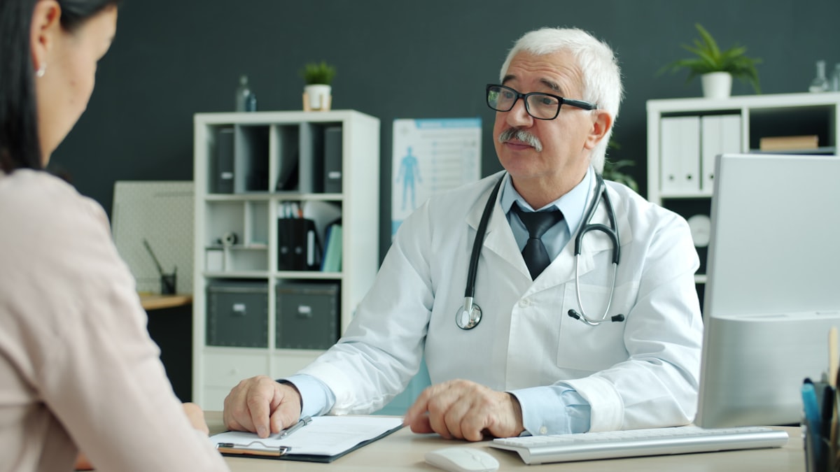 Arzt im Gespräch mit einer Patientin am Empfang